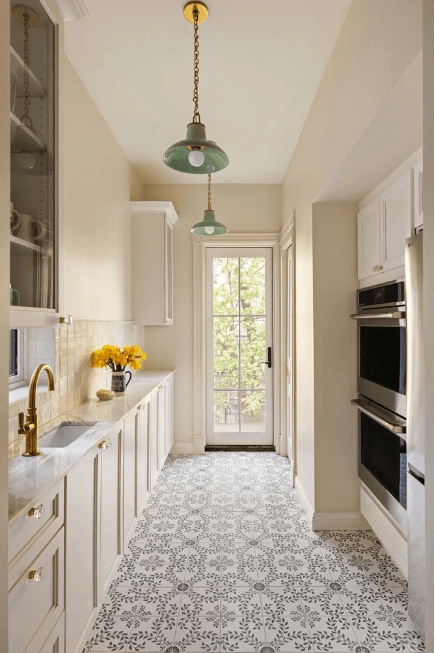 Bright galley kitchen with white cabinets and patterned tile